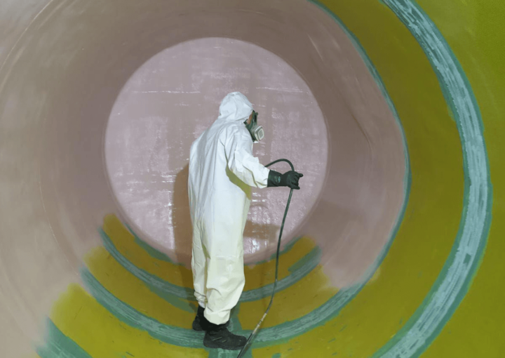 man spraying inside of a fuel tank