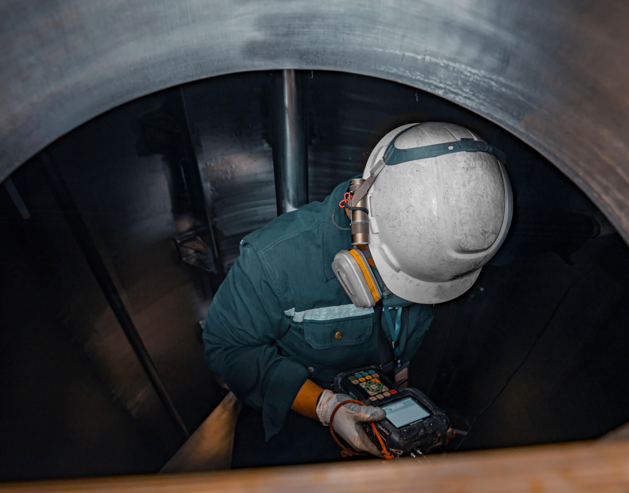 Man Inside of a Large Fuel Tank Inspecting It