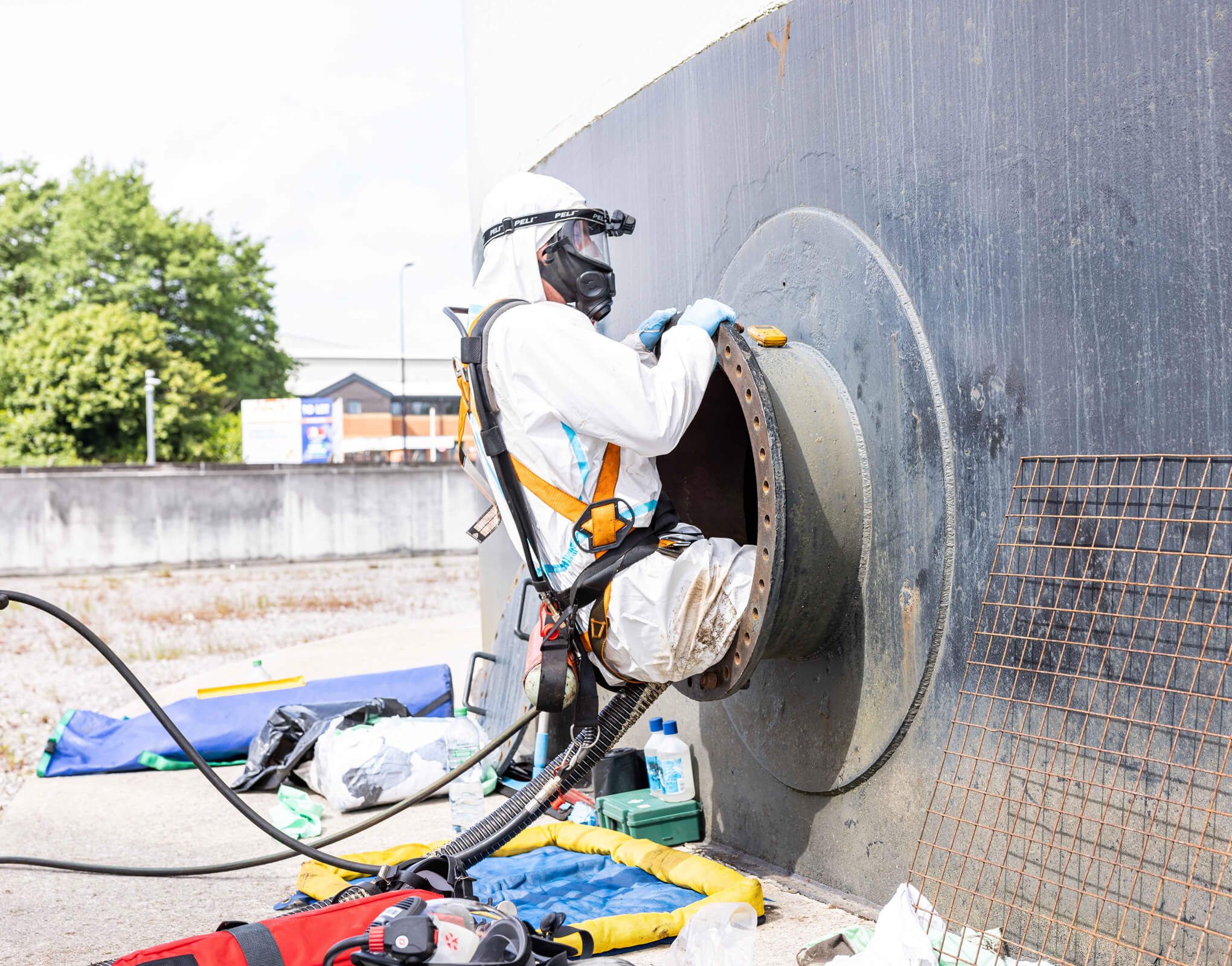 Man Entering a Small Hole in a Large Fuel Tank to Clean it