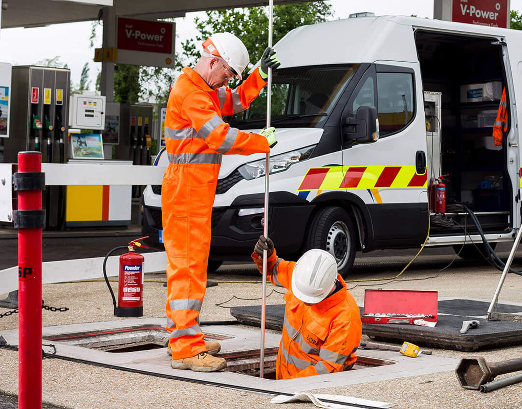 Two Engineers on a Fuel Forecourt Checking Fuel Tank