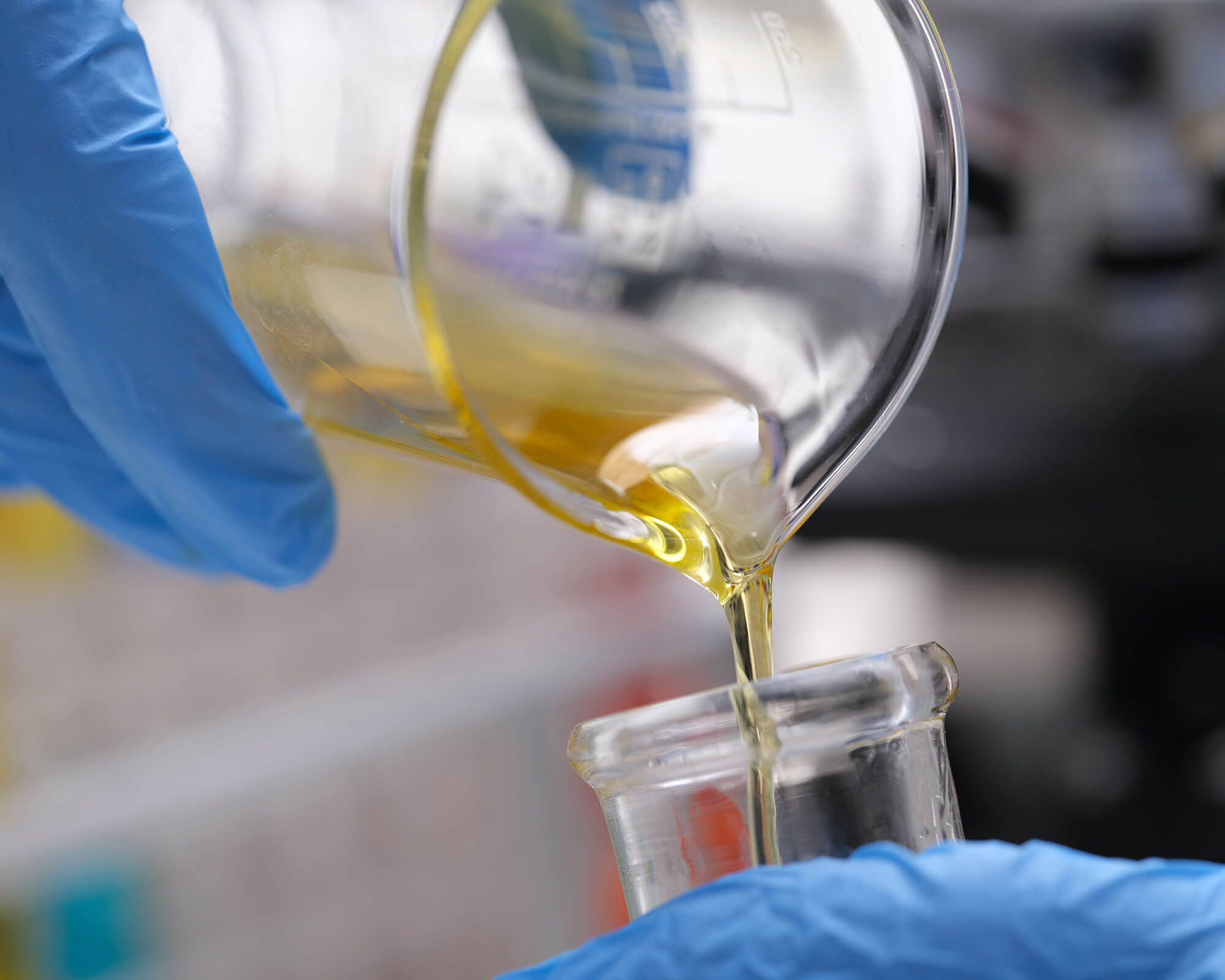 Pouring a Fuel Sample into a Test Tube Pouring a fuel sample from a glass jar into a test tube ready for testing.